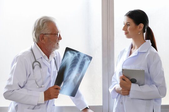 medical surgeon doctors team looking at x-ray film and discuss for treatment before surgery in the hospital.