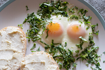 Fried eggs with greens close-up, healthy breakfast