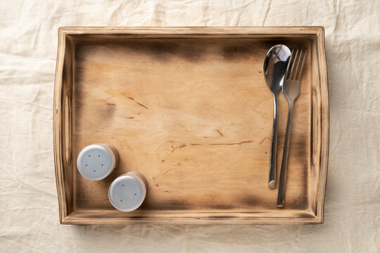 Empty wooden serving box with handles with spices and cutlery. Food and catering concept. Open container for food