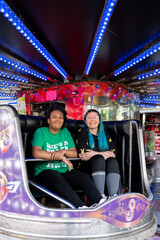 two sisters young women from a mixed race family on a. Walzer fairground ride 