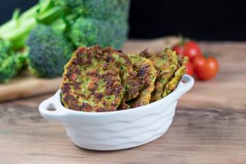 Green broccoli and pea pancakes, copy space. Healthy vegan food. Baked broccoli fritters on wooden...