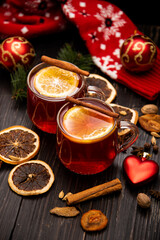 Fruity mulled wine on a wooden background with spices.