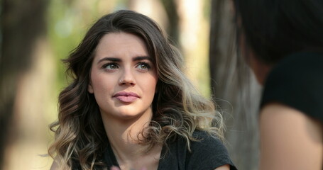 Fototapeta premium Candid friend listening to conversation outside at the park