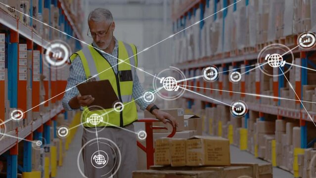 Animation of networks of connection with icons over caucasian man working in warehouse