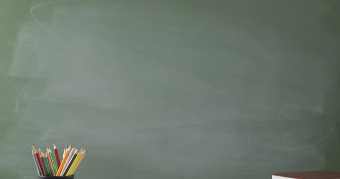 Video of books and cup with crayons on wooden table over mathematical formulas on blackboard