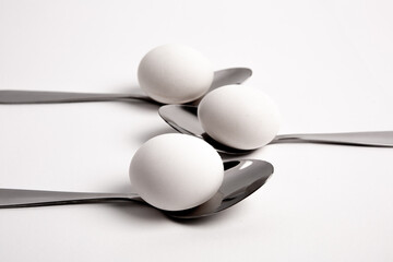 Chicken egg on metal forks, spoons isolated on white background close-up.
An egg that is set on top of two forks, spoons. Eggs have so many uses from diet to baking recipes.