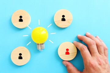 Education concept image. Creative idea and innovation. light bulb metaphor over blue background, wooden cubes and people icons