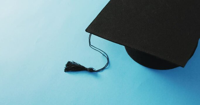 Video of graduation hat lying on blue background