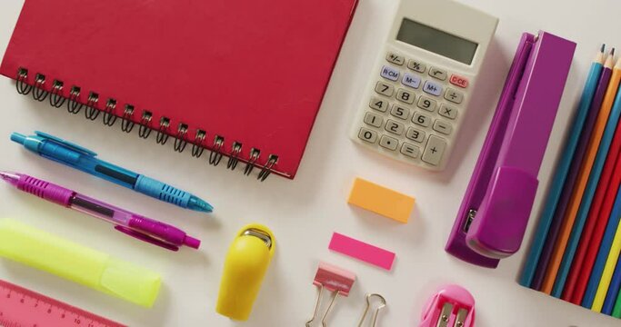 Video of composition of school items with notebook and calculator on white background