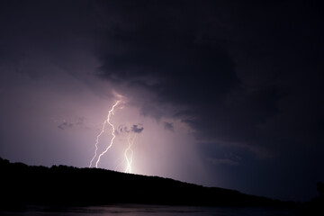 Naklejka na ściany i meble Fork lightning striking down during summer storm