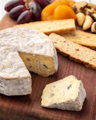 Brazilian artisan Bofete blue cheese with bread, nuts and fruits over wooden table