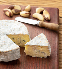 Brazilian artisan Bofete blue cheese with nuts over wooden table