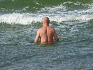bald old man in sea waves
