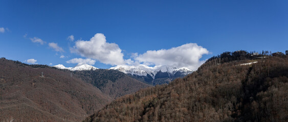 Peaks of a mountain range with cumulus clouds in Krasnaya Polyana