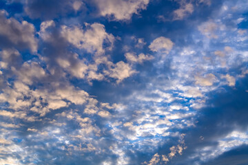 Cloudy evening sky after sunset in Iserlohn Germany. Panoramic view with dramatic light, contrasting clouds and blue to grey background at romantic wheater conditions. Wheather background at dusk.