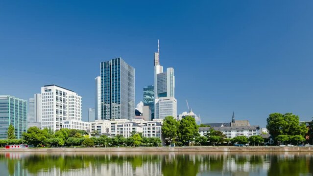 Frankfurt skyline hyperlapse time lapse, blue sky with clouds, office buildings and skyscraper in center with river and bridges in the foreground, Frankfurt am Main, Hessen, Germany