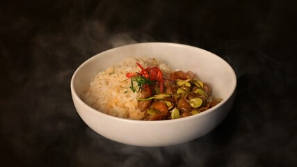 Stir Fried Sataw and Shrimp with Southern Curry Paste on rice. under the Smoke on black background.