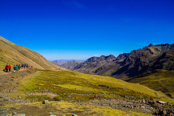 Unidentified tourists walking on the Rainbow Mountain (Vinicunca Montaña de Siete Colores - Spanish) in Cusco, Peru