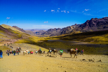 Unidentified tourists walking on the Rainbow Mountain (Vinicunca Montaña de Siete Colores - Spanish) in Cusco, Peru
