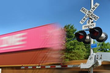 Blurred freight train containers in motion at crossing gate