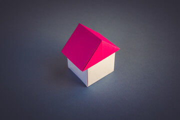 White and red paper house origami isolated on grey background