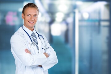Portrait of young male doctor posing on the background