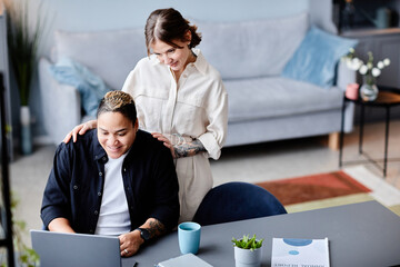 High angle portrait of modern gay couple using laptop at home together, copy space