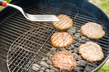 Selective focus of fresh delicious burger cutlets grilling on bbq grill