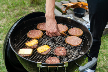 Selective focus of fresh delicious burger cutlets with cheese grilling on bbq grill