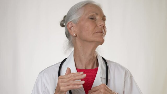 Portrait of overworked woman doctor rubbing forehead and look at camera, tired girl doctor feels headache from working hard.