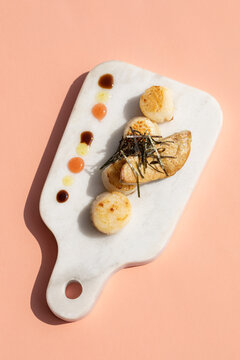 Scallops with foie gras on marble cutting board