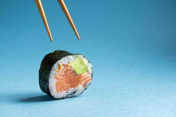 Futomaki sushi roll with chopsticks