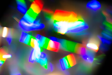Abstract blurred unfocused background with bright raibow colored lights on a dark background