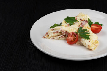 Omelet with Ham and Cheese and fresh vegetable on black wooden background