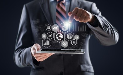 Businessman holding tablet with growing virtual hologram of statistics, graph and chart. Business strategy development and growing growth plan. Investment of growth on currency rate.