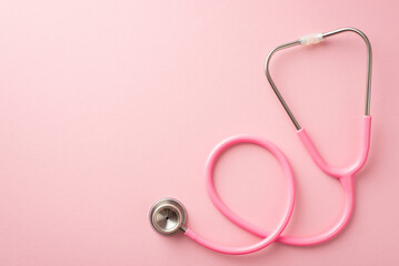 Breast cancer prevention concept. Top view photo of pink stethoscope on isolated pastel pink...