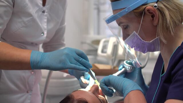 Female dentist at work with assistant