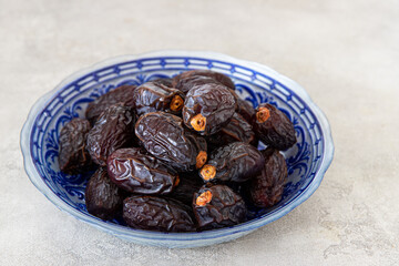 Fresh Medjool Dates in a bowl on  background