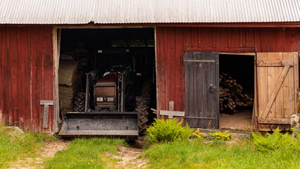 Fototapeta na wymiar tractor in old wooden barn