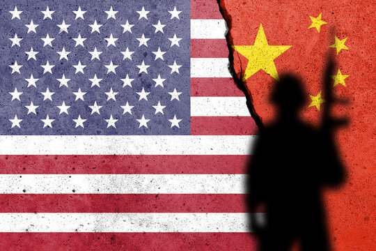 United States of America and China flags painted on the concrete wall with soldier shadow. USA and China war concept