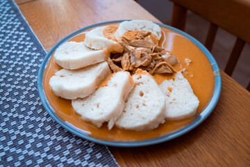 Traditional chicken hen on paprika or paprica creamy sauce with bread dumlings, typical czech food