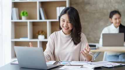 Beautiful Asian businesswoman sitting on a video call with a laptop meeting to discuss and discuss...