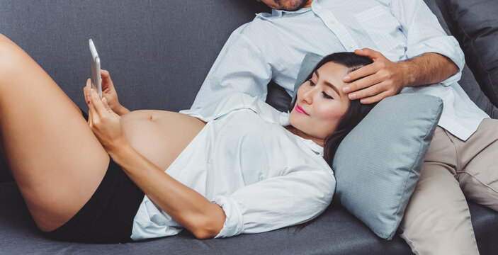 Adult couple woman and man spending time together in living room,Pregnancy woman with husband shopping online via tablet