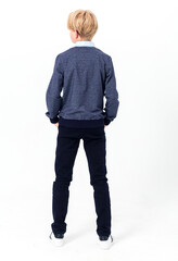 The boy poses in a school uniform - trousers, shirt, jacket and sneakers. A teenager stands with...