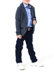 The boy poses in a school uniform on a white background. The model is wearing a shirt, jacket, pants and sneakers