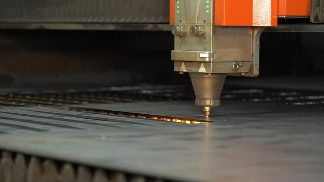 Close-up CNC laser cutting machine. 
The metal sheet is cut on the cnc machine and holes are drilled on it. Laser cutting device following laser light and laser light.  Cutting of industrial metal par