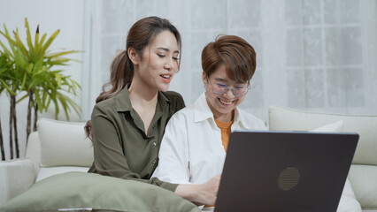 Holiday concept of 4k Resolution. Asian women playing laptops together in the living room. Young...