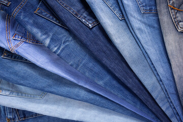 Blue jeans denim heap background. Jeans fabric stack as material surface