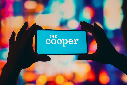 August 2, 2022, Brazil. In this photo illustration, a silhouetted woman holds a smartphone with the Mr. Cooper logo displayed on the screen.