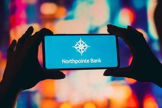 August 2, 2022, Brazil. In this photo illustration, a silhouetted woman holds a smartphone with the Northpointe Bank logo displayed on the screen.